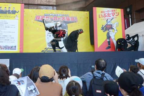 ヒーローショーで、霧が出る武器を使い敵を倒す「いぶたマン」＝３日、鹿児島市のＪＲ鹿児島中央駅前アミュ広場