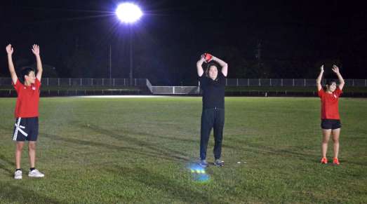 投てきのトレーニングを指導する北口榛花選手（中央）＝奄美市名瀬の名瀬運動公園