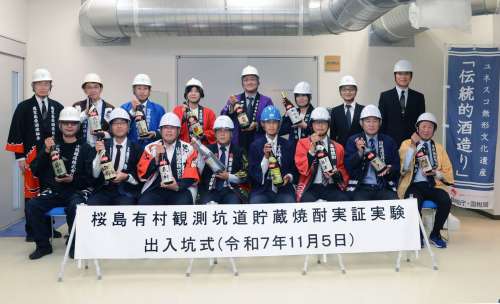 １年間貯蔵した焼酎を手にする蔵元ら＝５日、鹿児島市の桜島有村観測坑道