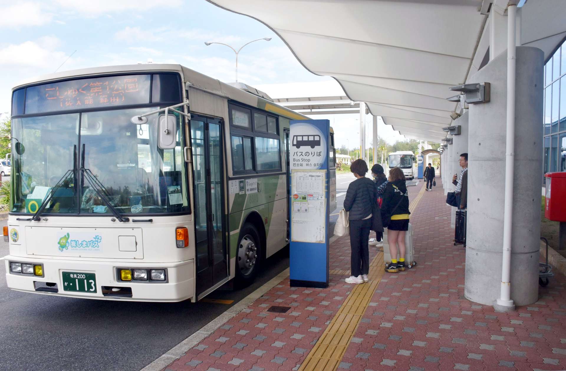 奄美空港で路線バスを待つ観光客ら＝奄美市笠利