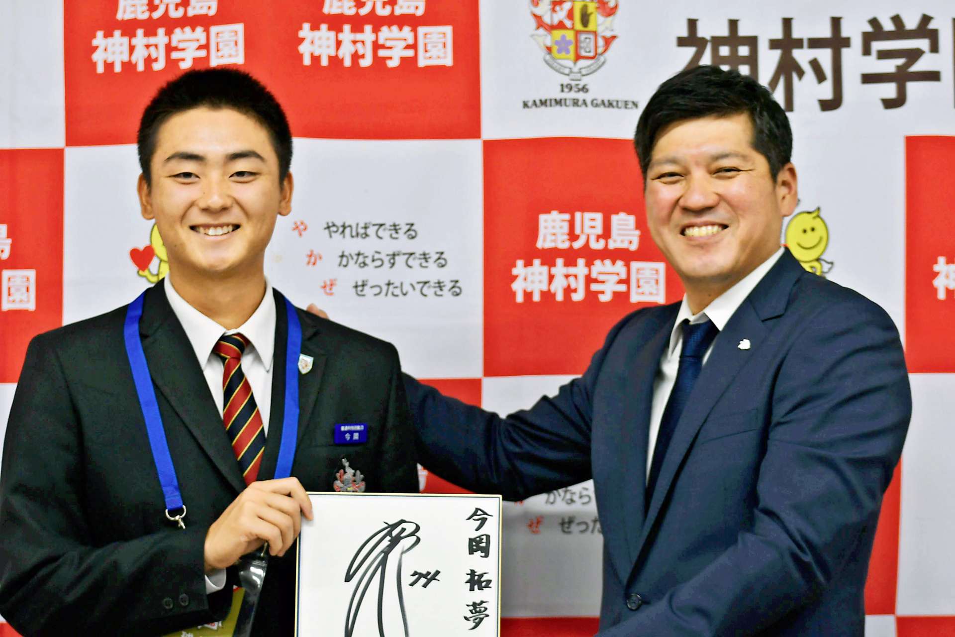 指名あいさつを受け、西武の西口監督のサイン入り色紙を手渡す岳野竜也スカウト（右）と神村学園高の今岡拓夢内野手＝同校