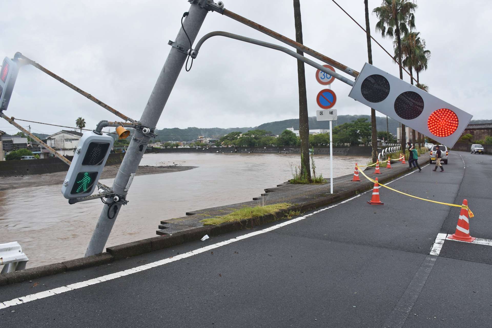 土台が崩れて傾いた信号機＝８月８日午前９時１５分、姶良市加治木の網掛橋付近