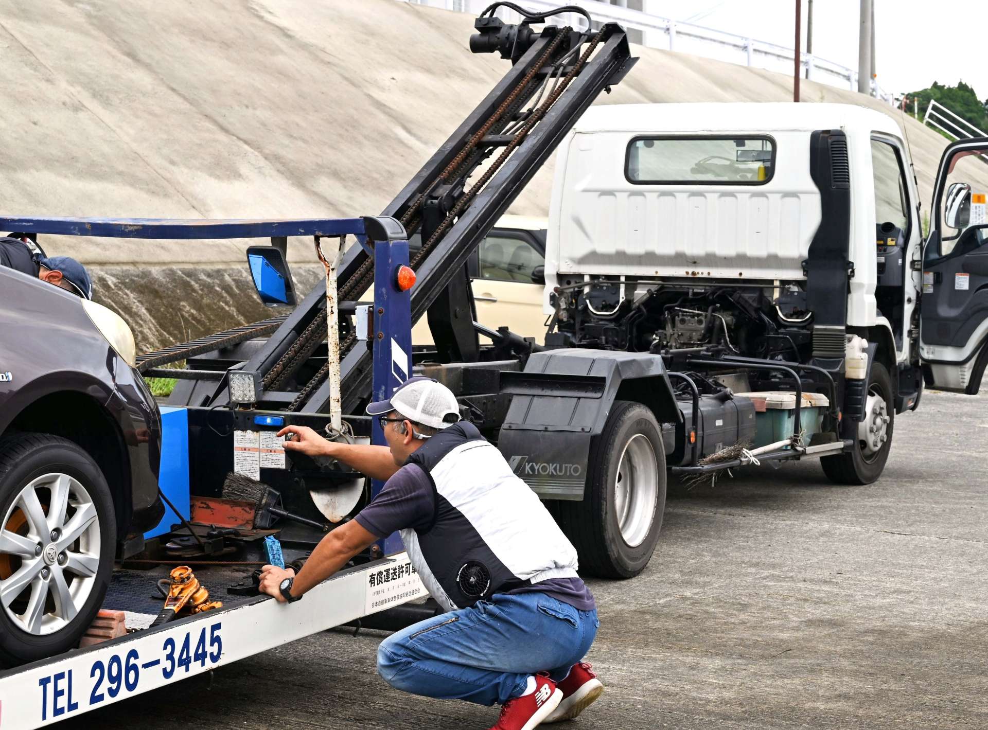 水没して動けなくなった車を運ぶ整備工場のスタッフ＝８月２３日、南さつま市加世田