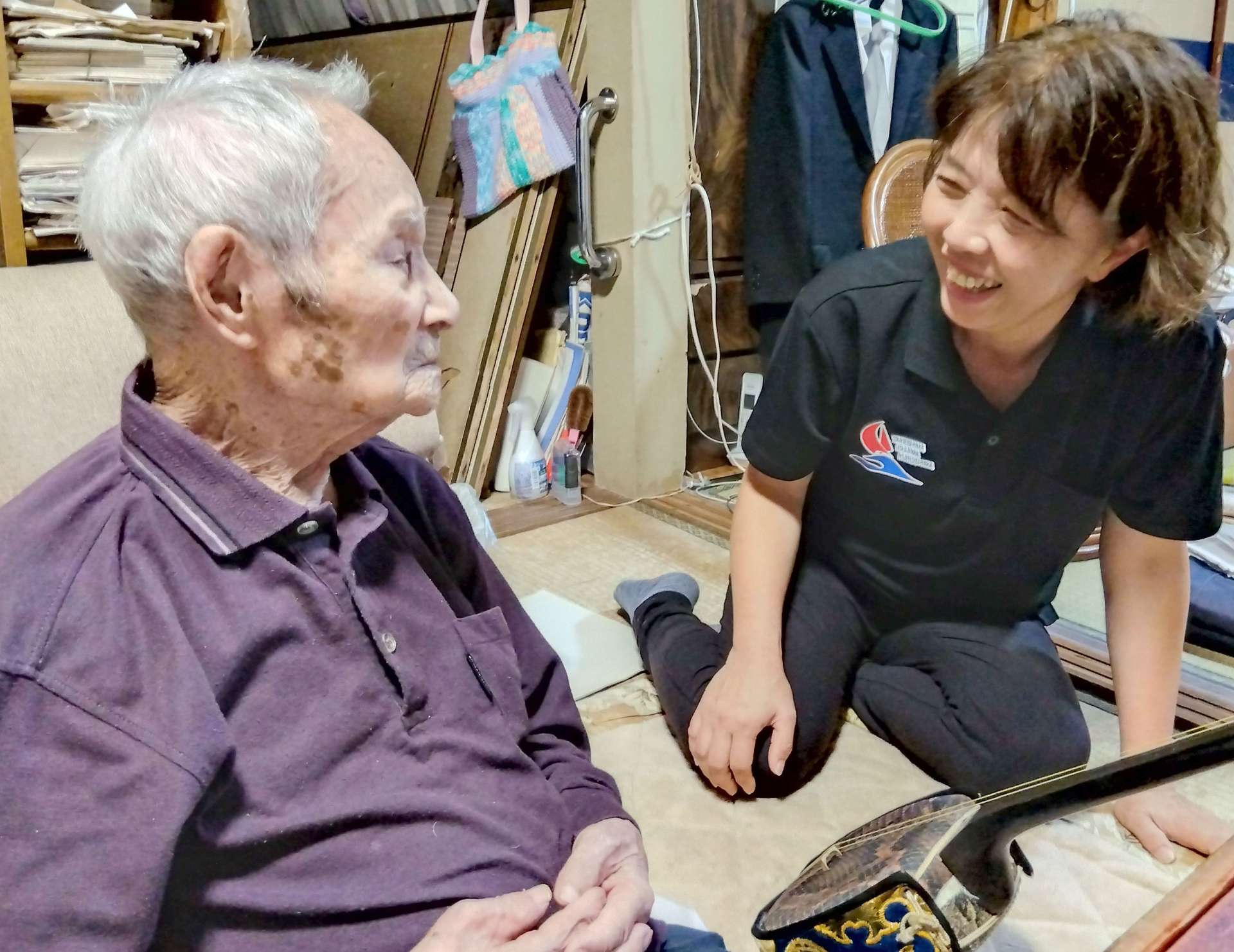 訪問先で高齢者に体調などを尋ねる日高真弓さん（右）＝三島村黒島