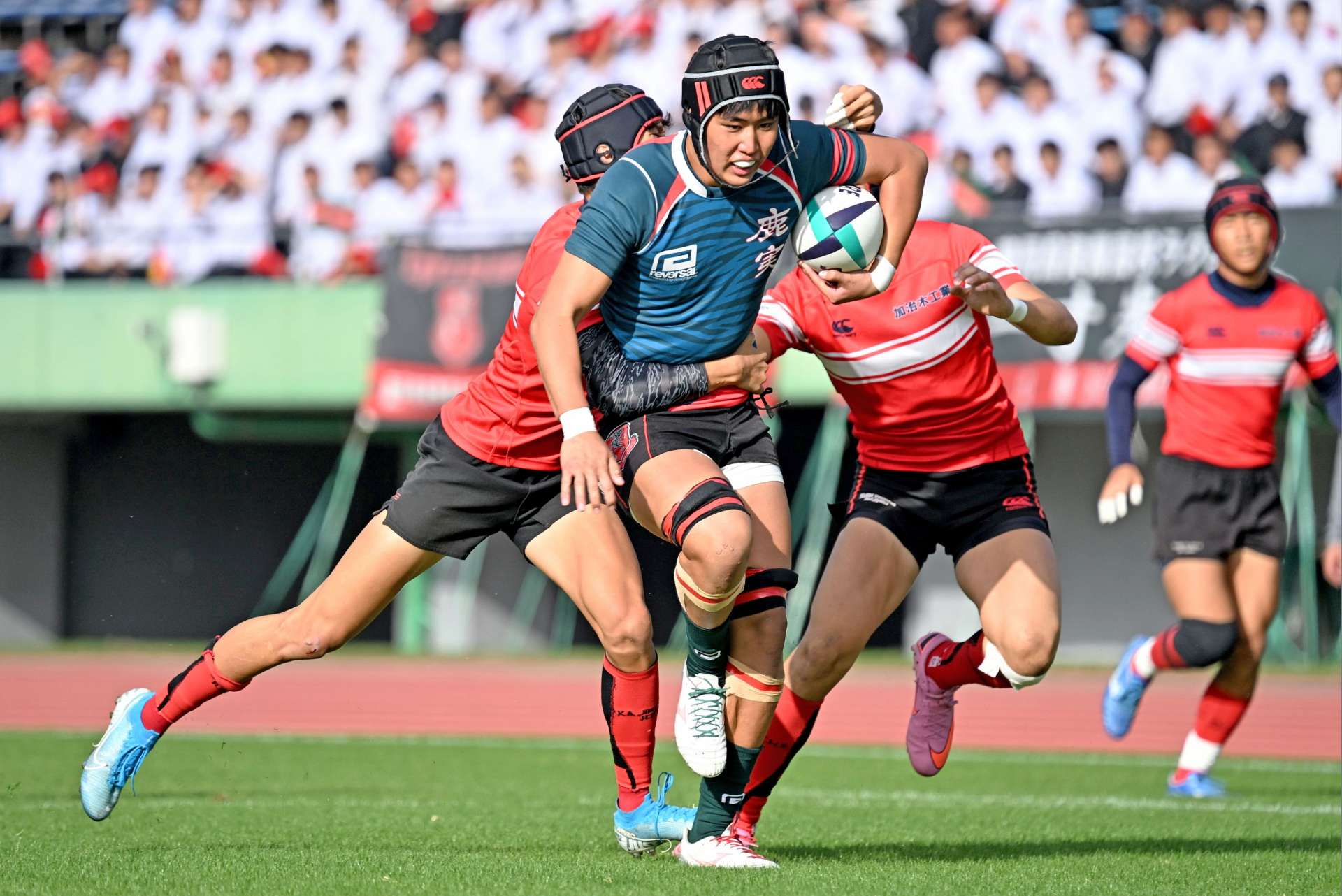 前半、攻め上がる鹿実の選手＝白波スタジアム