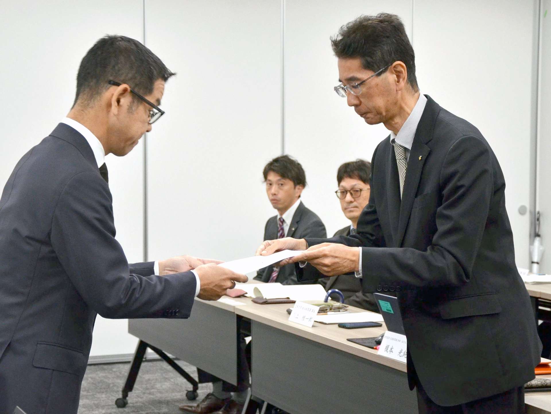 ＪＲ九州の海老原毅鹿児島支社長（左）に要望書を手渡す県総合政策部の伊瀬知強参事＝１１日、鹿児島市の同支社