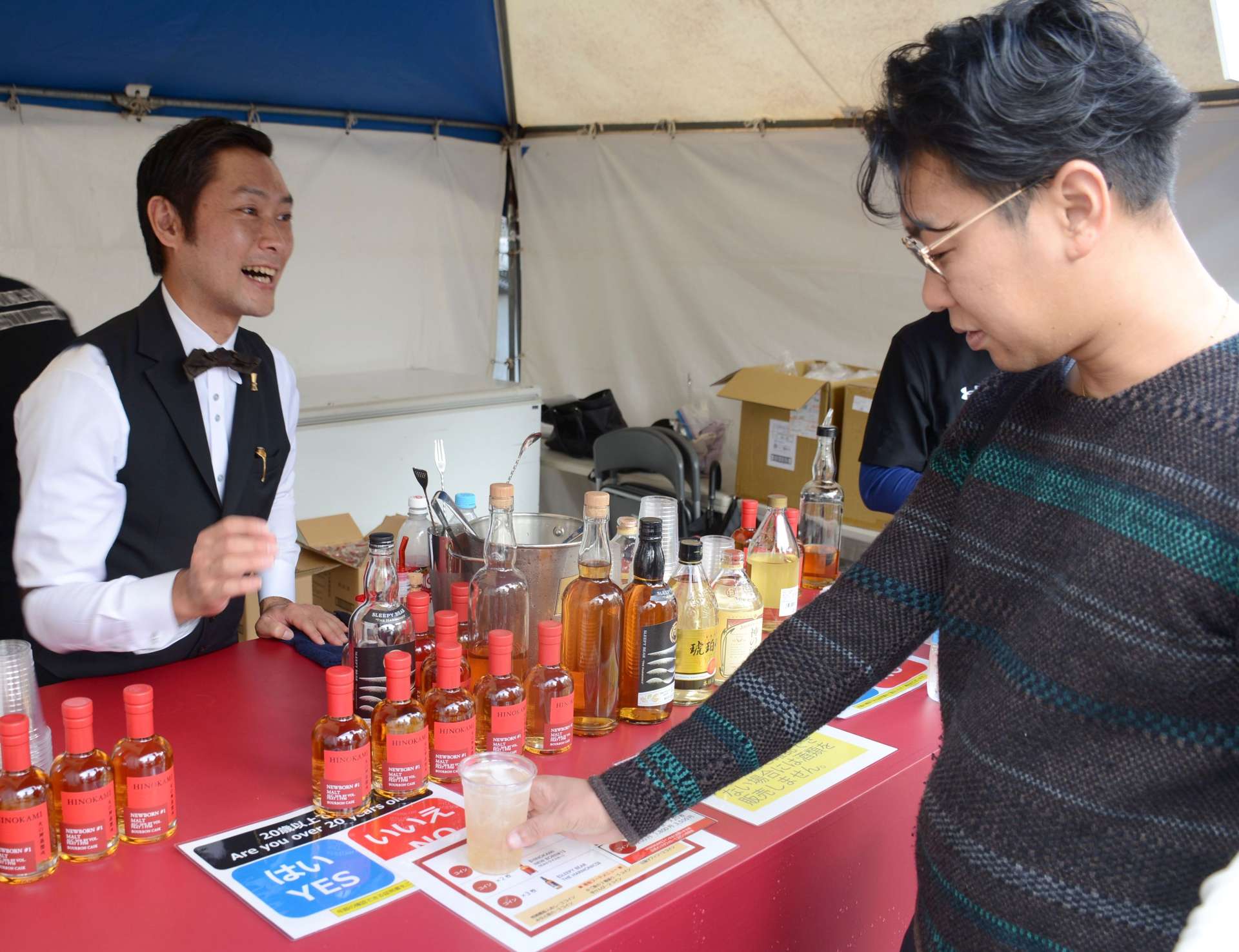 新発売のウイスキーの炭酸割りを受け取る来場者＝枕崎市火之神北町