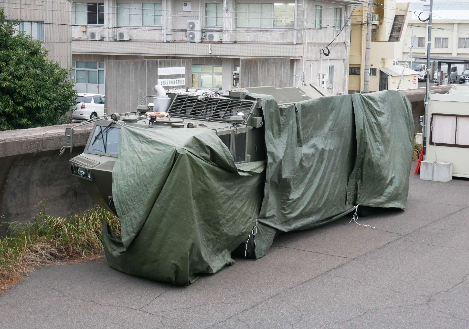 幕をかぶり、ひっそりと待機する水陸両用車＝１２日、鹿児島市錦江町