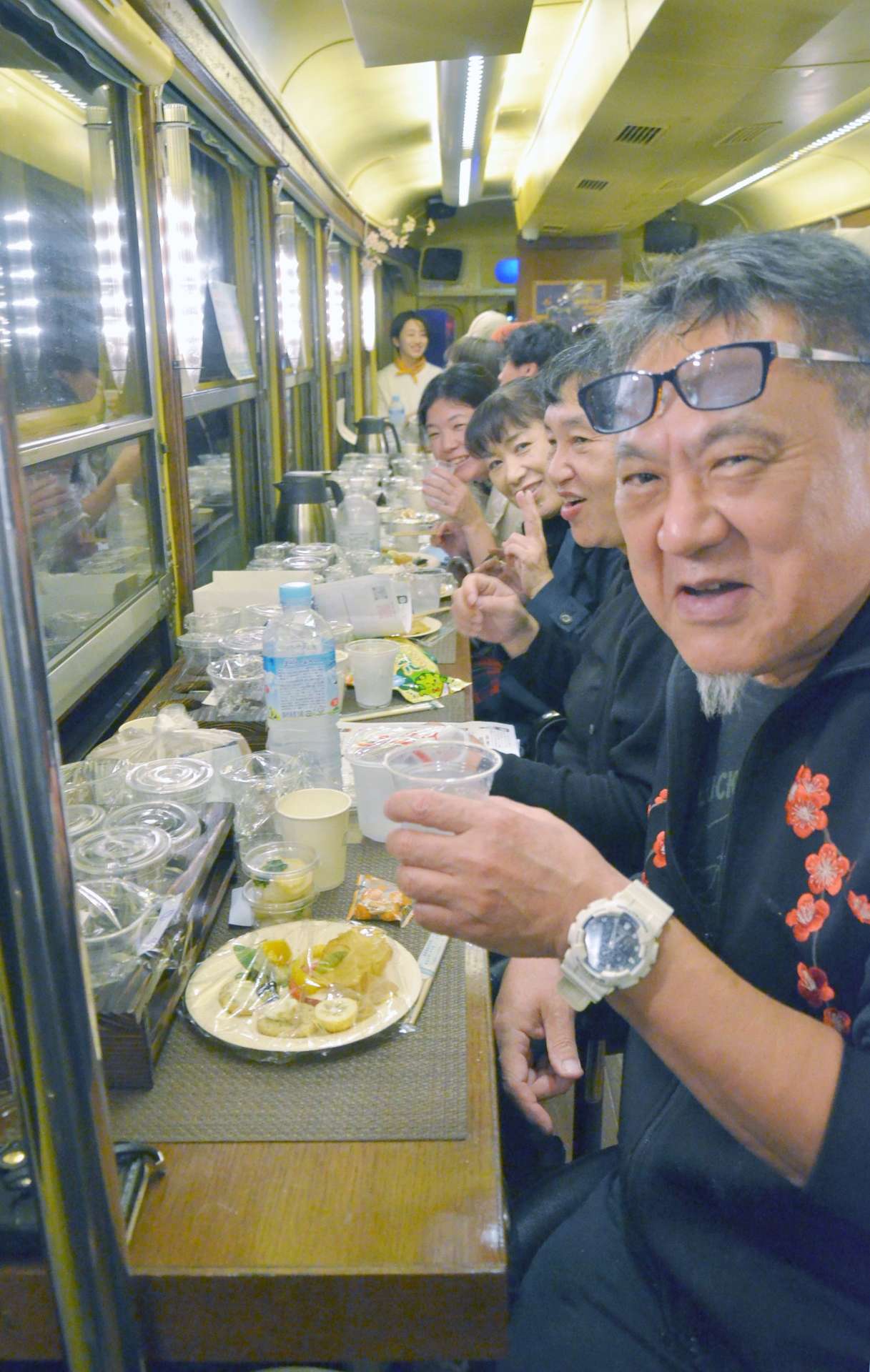 女性農業者が中心となって企画した鹿児島市電で焼酎を楽しむイベントの参加者ら＝１３日夜、鹿児島市