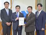 塩田康一知事（左から２人目）に要望書を手渡す松田浩孝団長（同３人目）＝１４日、県庁