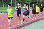 トラックを走り込み、汗を流す選手たち＝１５日、指宿市営陸上競技場