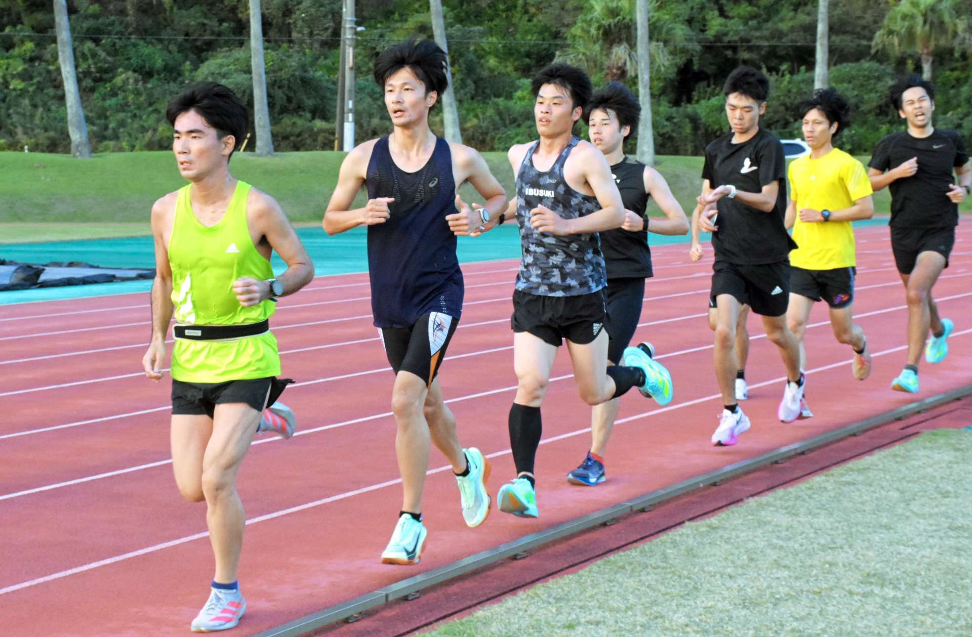 トラックを走り込み、汗を流す選手たち＝１５日、指宿市営陸上競技場