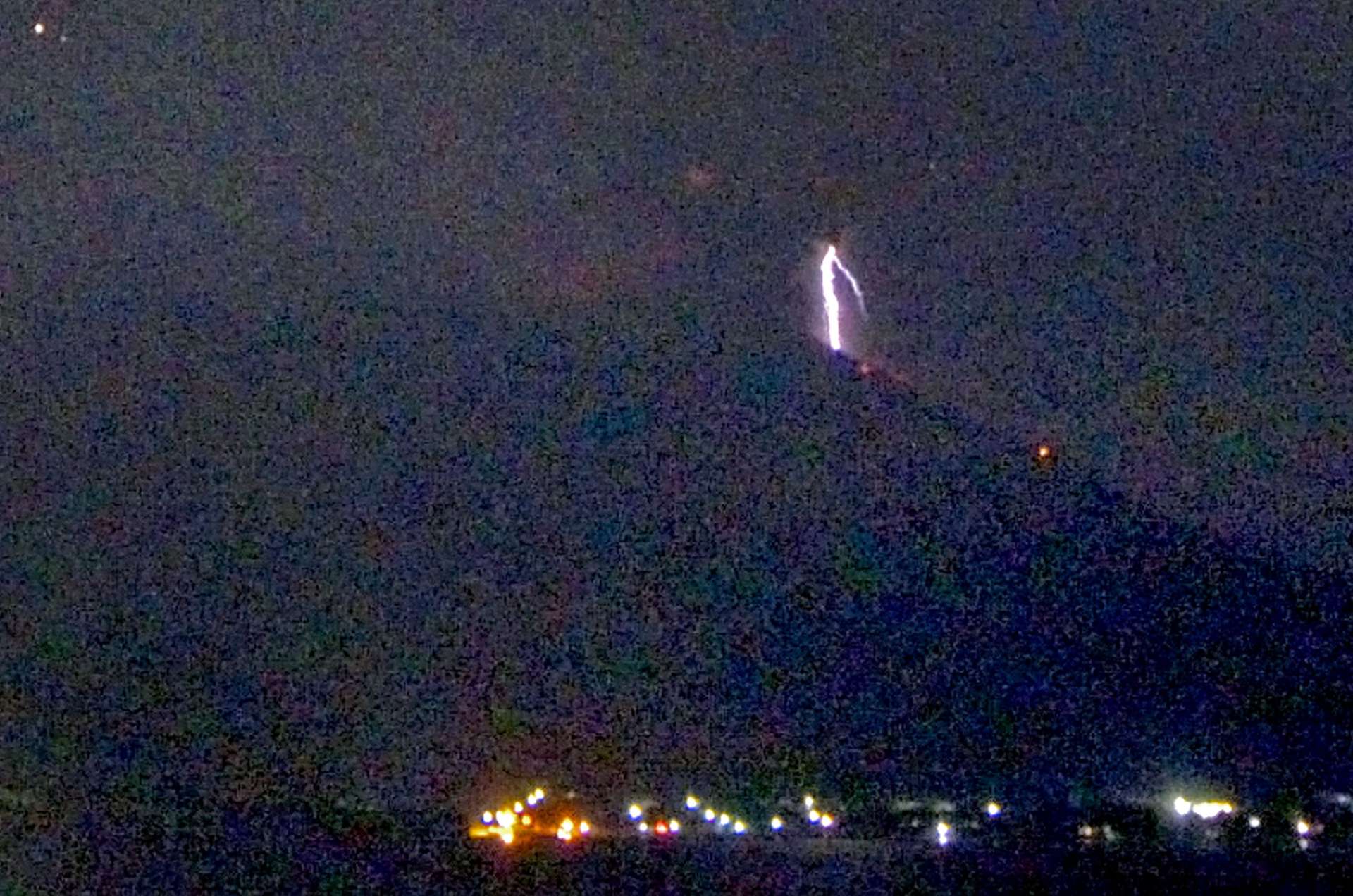 爆発に伴う火山雷が見られる桜島＝１６日午前０時５７分、鹿児島市与次郎１丁目（南日本新聞社監視カメラ）