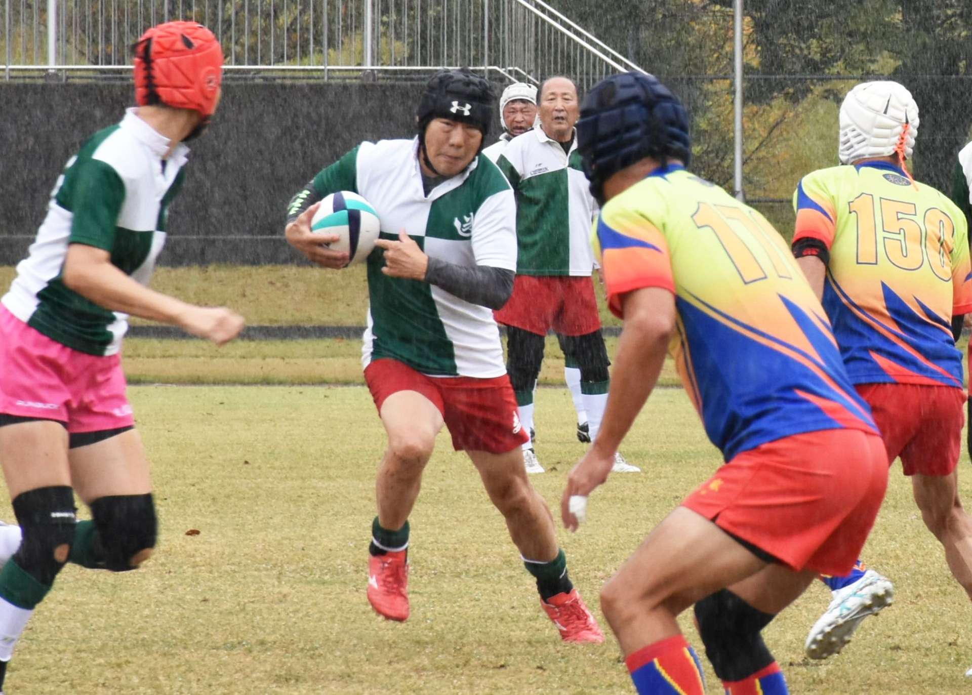 ボールを追い全力でプレーするシニアラグビー選手ら＝伊佐市陸上競技場