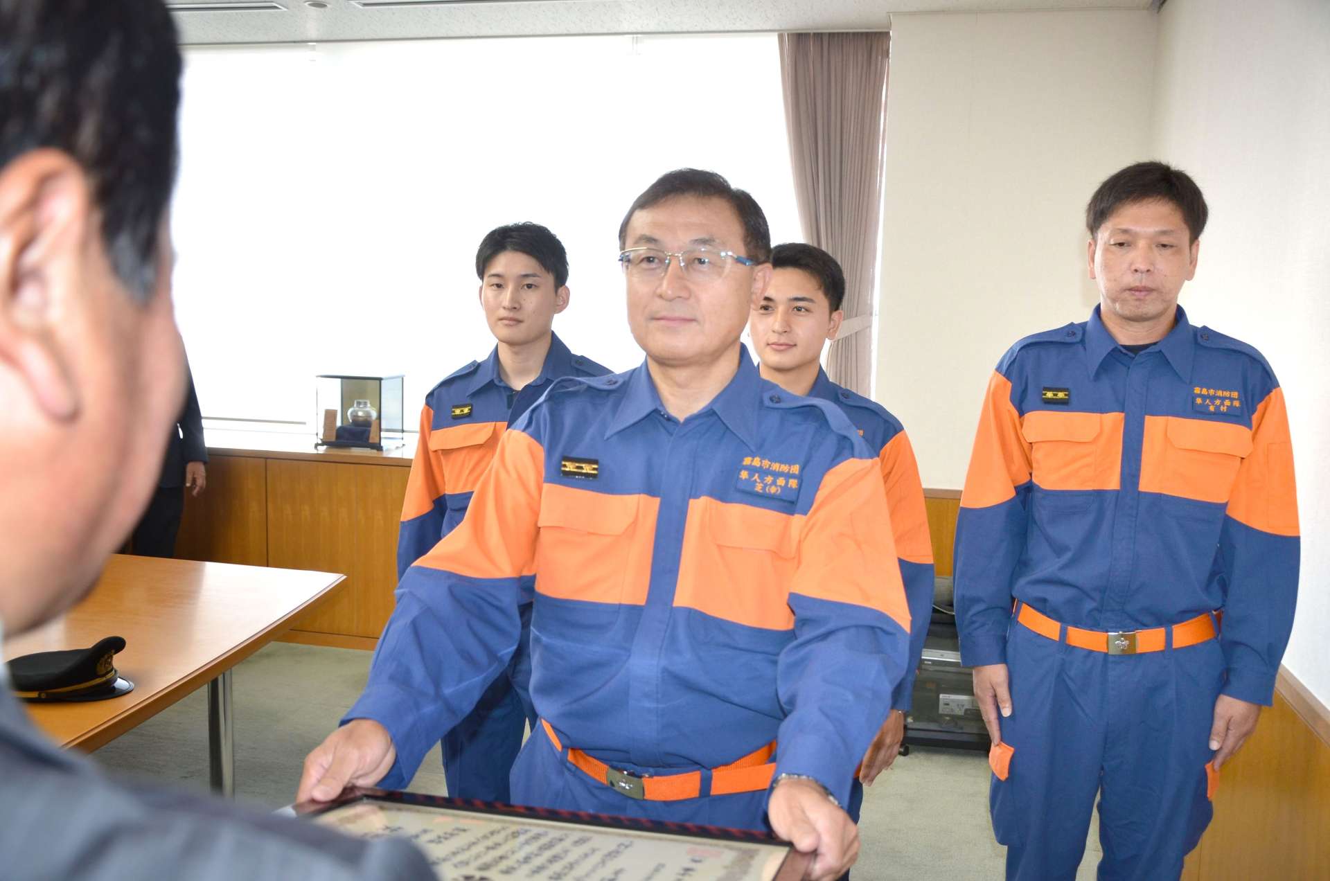 市長表彰を受ける霧島市消防団隼人方面隊日当山第二分団姫城部の芝幸宏部長ら＝霧島市役所