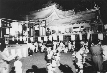 昭和44年7月、旧隼人町の鹿児島神宮。当時の紙面は「緑のライトを浴びせ、夜空に浮きたたせる投光テストが地元観光協会によって進行中。樹木に反射した光が美しく、三キロ離れたところからもはっきりわかった」と報じている。