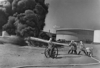 昭和４４年９月、喜入原油基地であった防災訓練で、大型消火器を使う基地自衛消防隊。「オイルセパレーター横に設けられた池にガソリン２０リットルをまいて点火。消化液“エアフォーム”を使って消火訓練を行った」と紙面は伝えている。