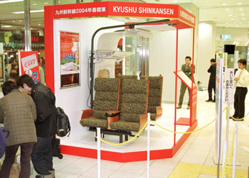 平成１５年３月、九州新幹線一部開業前に西鹿児島駅構内に設置された、８００系車両の座席。紙面は「実際に使われる座席と同じで、座りごこちも体験できる。一足早い新幹線の“一部登場”が、切符を求める客らの目を引いていた」と伝えている。