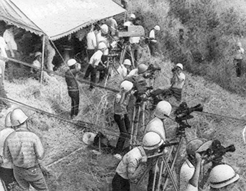 昭和４３年９月１０日、内之浦町長坪台地の報道席。この日内之浦上空は快晴。心配されていた宮崎県南郷漁協シビなわ船主組合の実験阻止の出漁も中止され、東大実験班はこの日の空のように晴れ晴れとした表情。見学席はずらりとカメラの放列。実験班は「ラムダのときより多いじゃないか」と驚き顔。